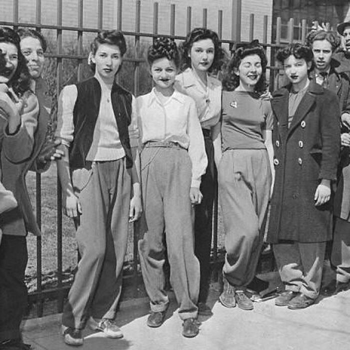 Group of young women in vintage clothing standing outdoors, illustrating weird things about history in black and white.