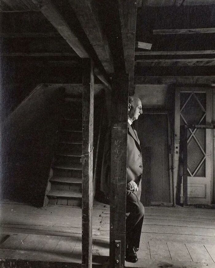 Black and white photo of a man standing in an old wooden attic, illustrating weird things about history.