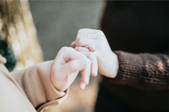 Close-up of two people holding hands outdoors, illustrating relationship icks and communication issues with cats.