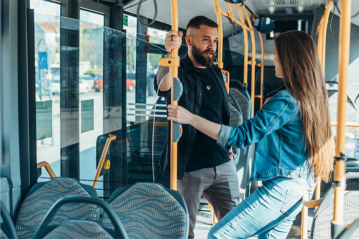 A woman and man standing in a bus having a serious conversation about relationship icks women experienced.