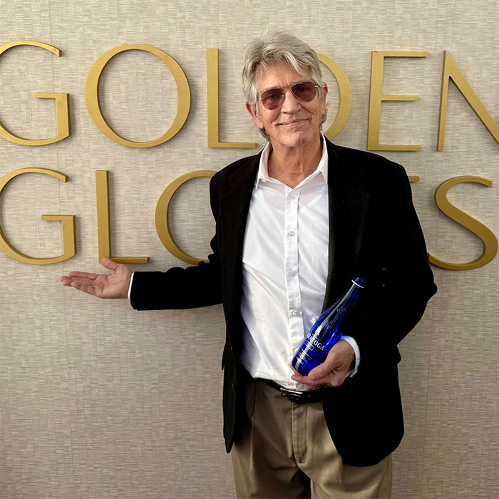 Actor Eric Roberts at Golden Globes event holding a bottle, representing actors in the most movies across every genre.