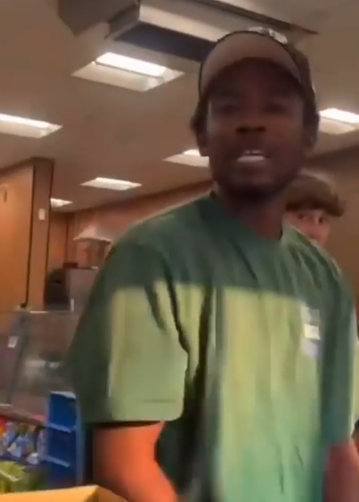 Man in green shirt involved in a viral store brawl after calling Black shopper a slur and getting beaten.