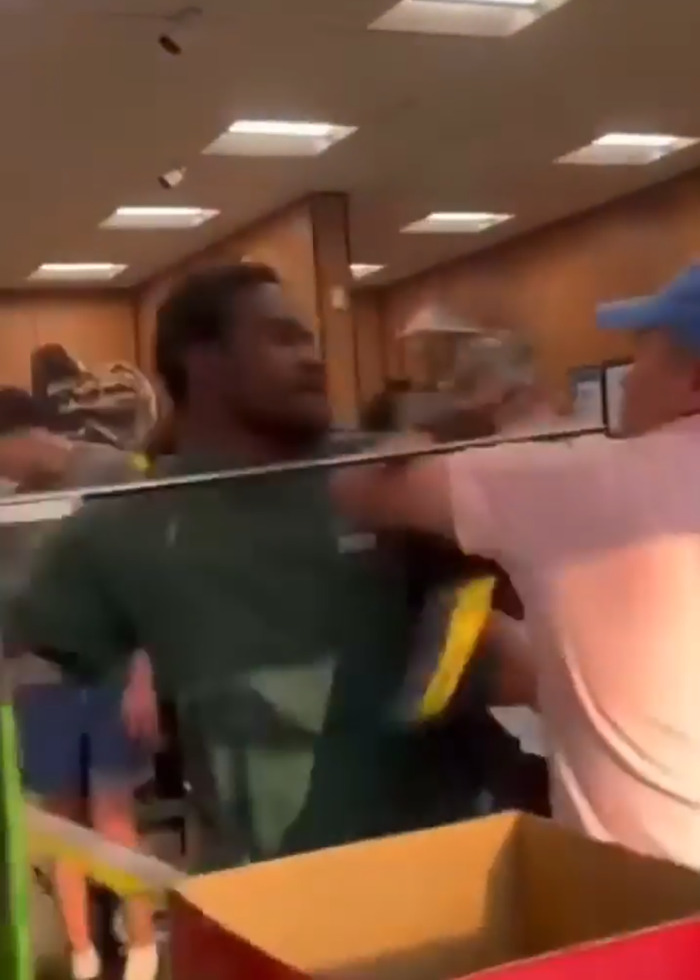 Two men fighting aggressively inside a store during a viral brawl involving a racial slur incident.