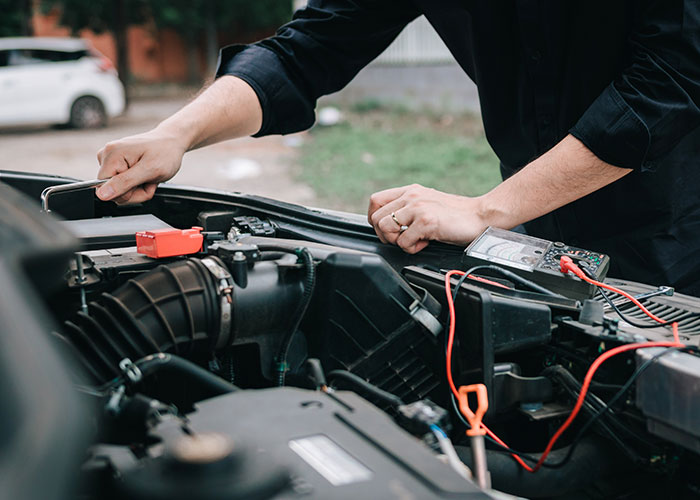 Person helping fix a car engine, illustrating wholesome interactions with strangers through acts of kindness and support.
