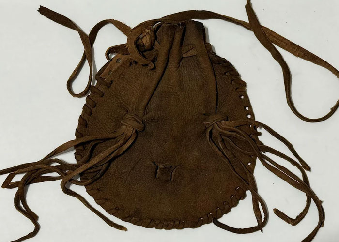 Brown leather pouch with drawstrings, representing a wholesome interaction token shared between strangers.