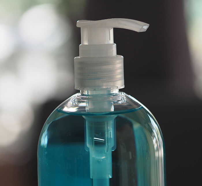 Close-up of a liquid soap bottle with a pump showing design flaws causing user frustration and product usability issues.