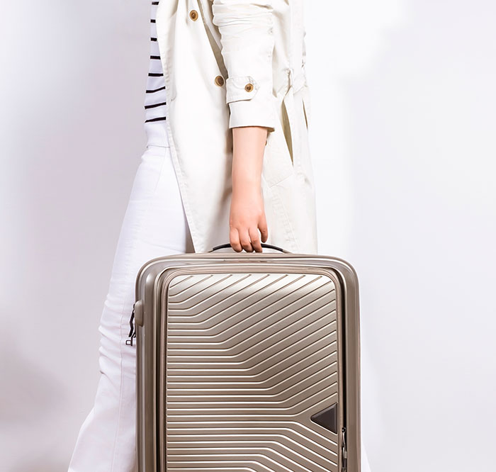 Person holding a suitcase with design flaws, illustrating products with design flaws that cause frustration and rage.