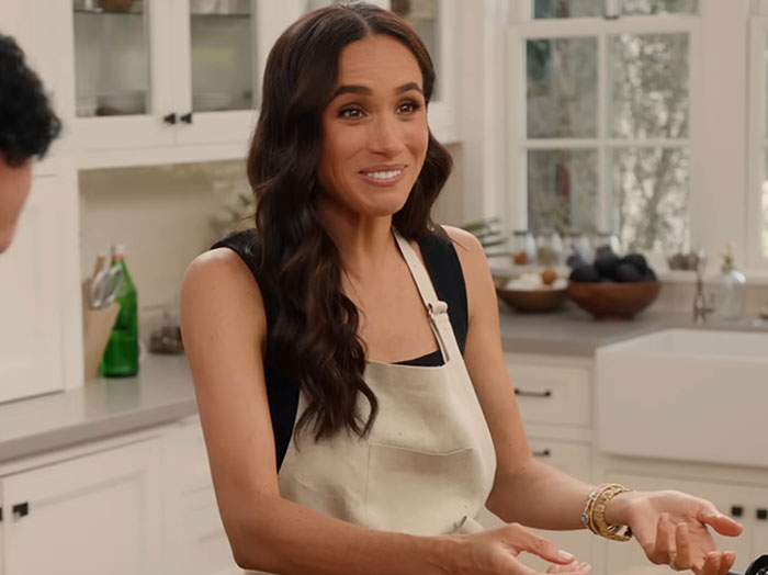 Meghan Markle in a kitchen setting sharing her cooking hack, facing criticism for the kitchen hack she revealed.