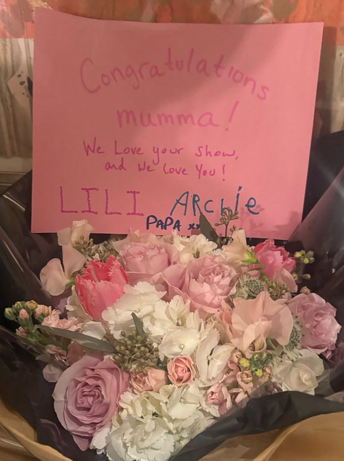 Bouquet of pink and white flowers with a handwritten congratulations card, related to Meghan Markle kitchen hack controversy.