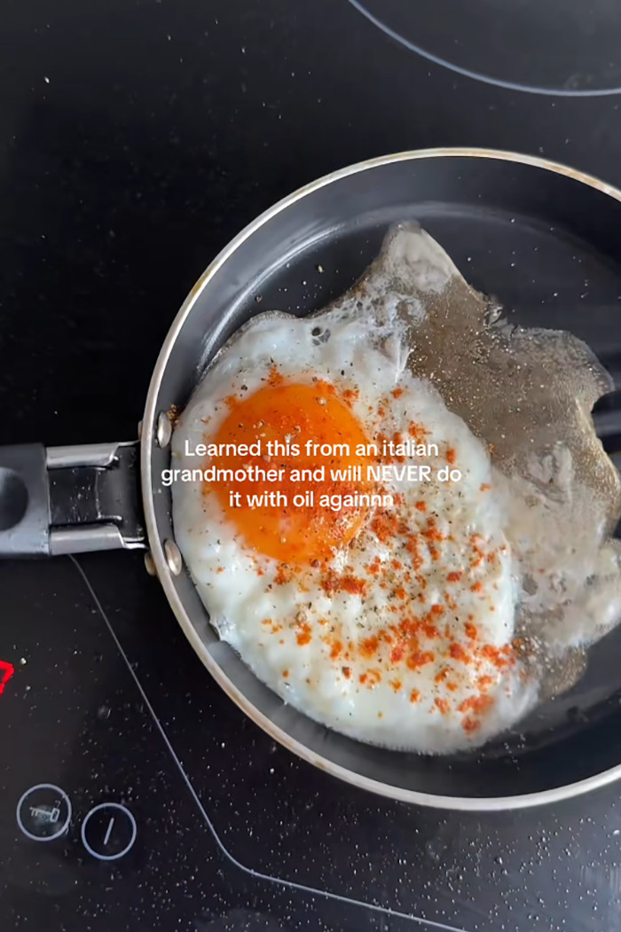 Fried egg cooking in a pan using a bizarre egg frying technique learned from Italian grandmother with seasoning added. Fried egg cooking in a pan using a bizarre egg frying technique learned from Italian grandmother with seasoning added.