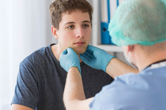 Doctor examining teenage boy’s face, relating to stepson’s surgery and family medical decision discussions. Doctor examining teenage boy’s face, relating to stepson’s surgery and family medical decision discussions.