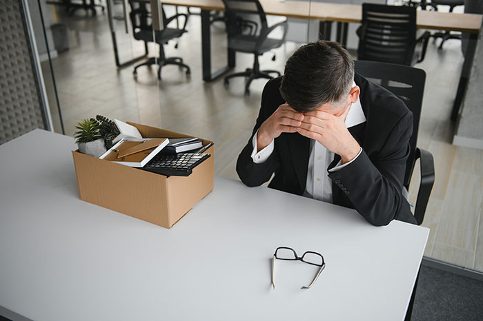 Man sitting at office desk with head in hands after pulling harmless prank, girlfriend&rsquo;s sister panics then gets revenge