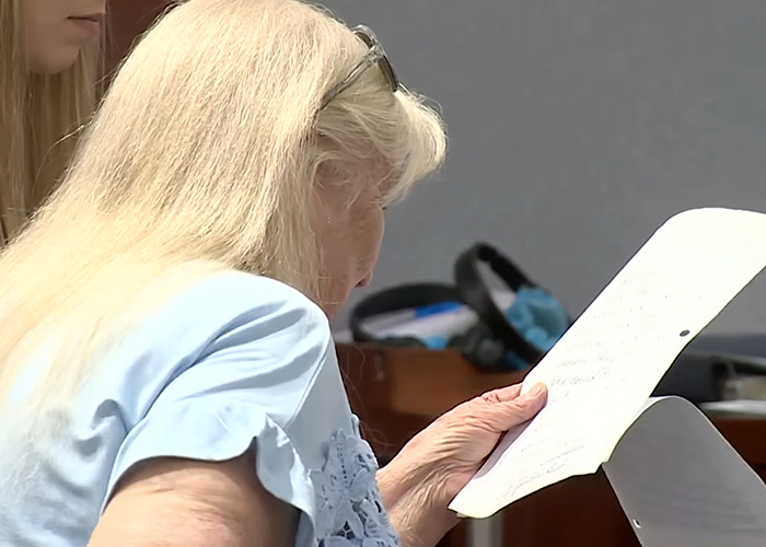 Woman with long blonde hair reading court documents related to sentencing in a case involving a tampon incident.