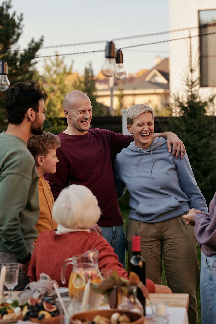 Group of people smiling and laughing outdoors, highlighting experiences with disrespectful partner families and relationship challenges.