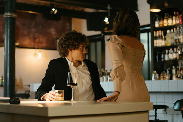 A young couple at a dimly lit bar, capturing a tense moment during one of the worst dates servers witnessed at work.