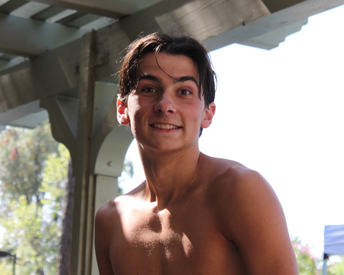 Teenage boy smiling shirtless outdoors with trees in background, related to terrifying words hallucinating 14YO son said story.