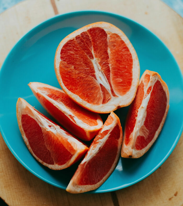 Sliced grapefruit on a blue plate, unrelated to doctors sharing shocking discoveries made during autopsies.