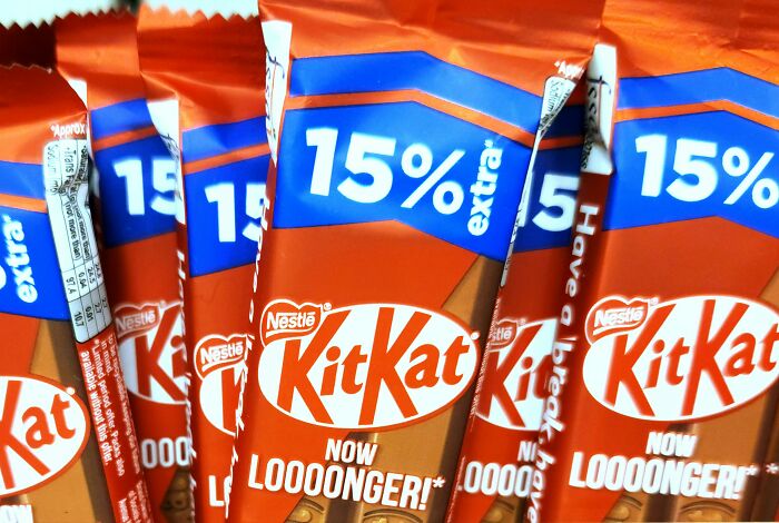 KitKat chocolate bars with packaging highlighting 15% extra, linked to Americans revealing non-Americans habits like breaking spaghetti.