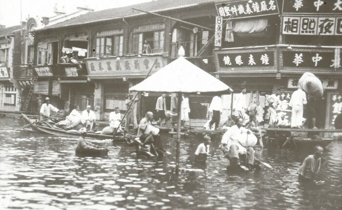Flood damage in a historic urban area showing people coping with natural disasters larger than usual in the last century