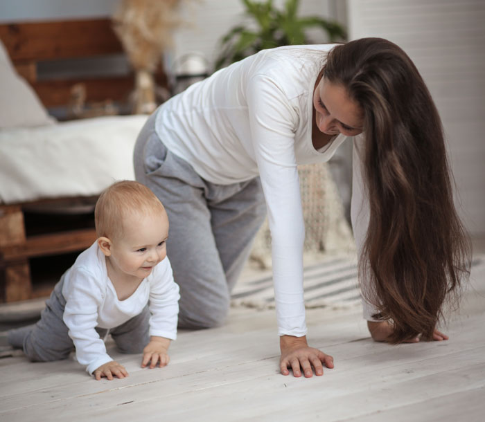 Young nanny playing on the floor with baby in casual home setting, highlighting nanny work and childcare concepts. - 1