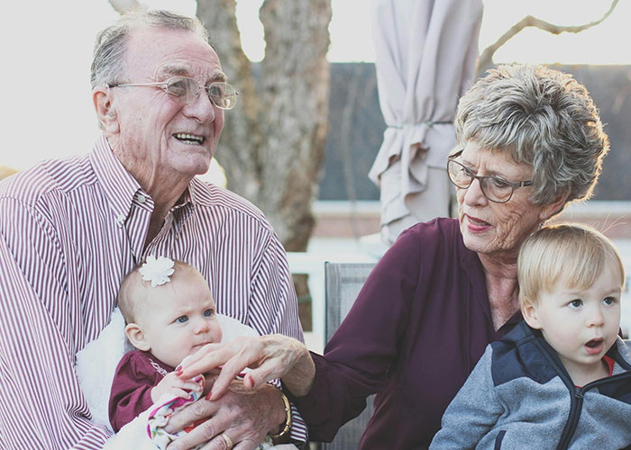 Elderly grandparents interacting with young children, illustrating differences in modern parents and family dynamics. Elderly grandparents interacting with young children, illustrating differences in modern parents and family dynamics.