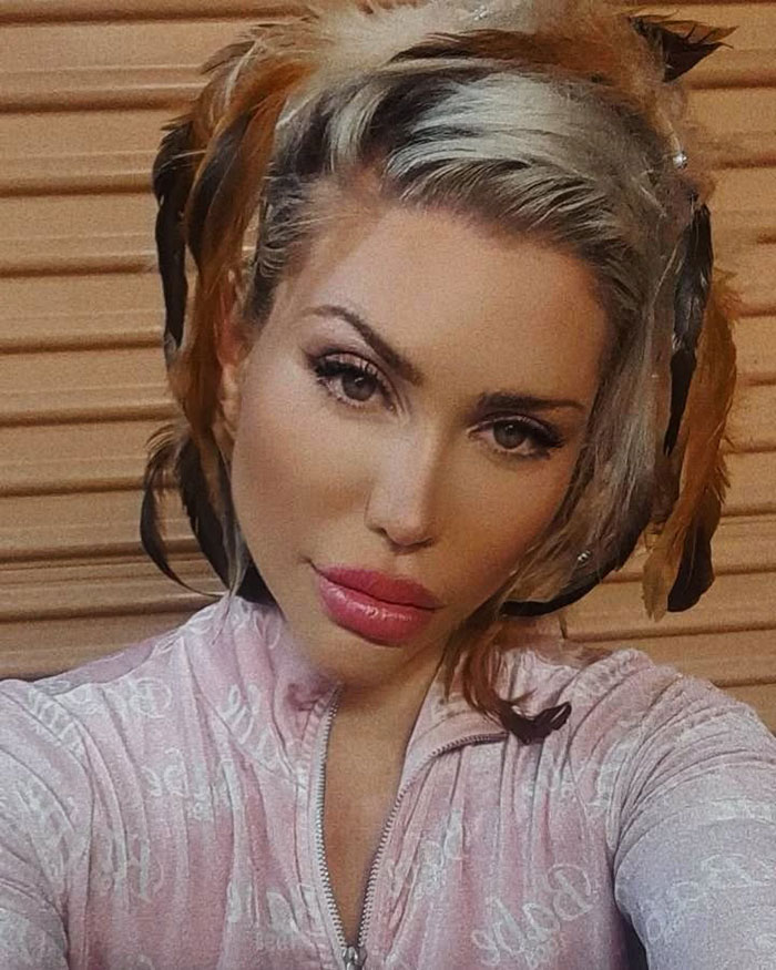 Reality star with blonde hair wearing a pink top, posing for a selfie related to a murder charge news story.