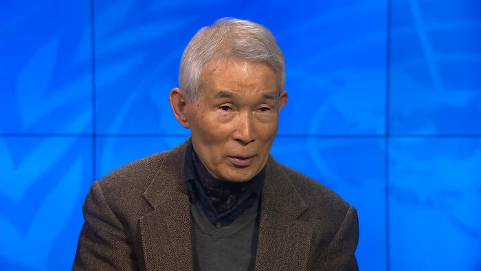 Elderly man in a brown jacket sharing insights about crazy historical events that seem unreal in modern times.