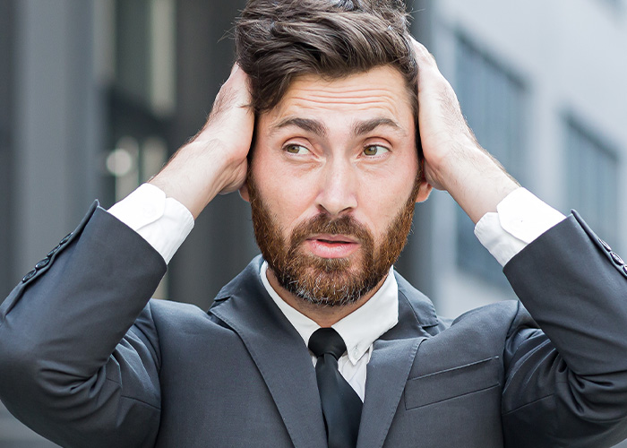 Stressed man in business suit outdoors reacting to ridiculous complains from employees to managers and HR.