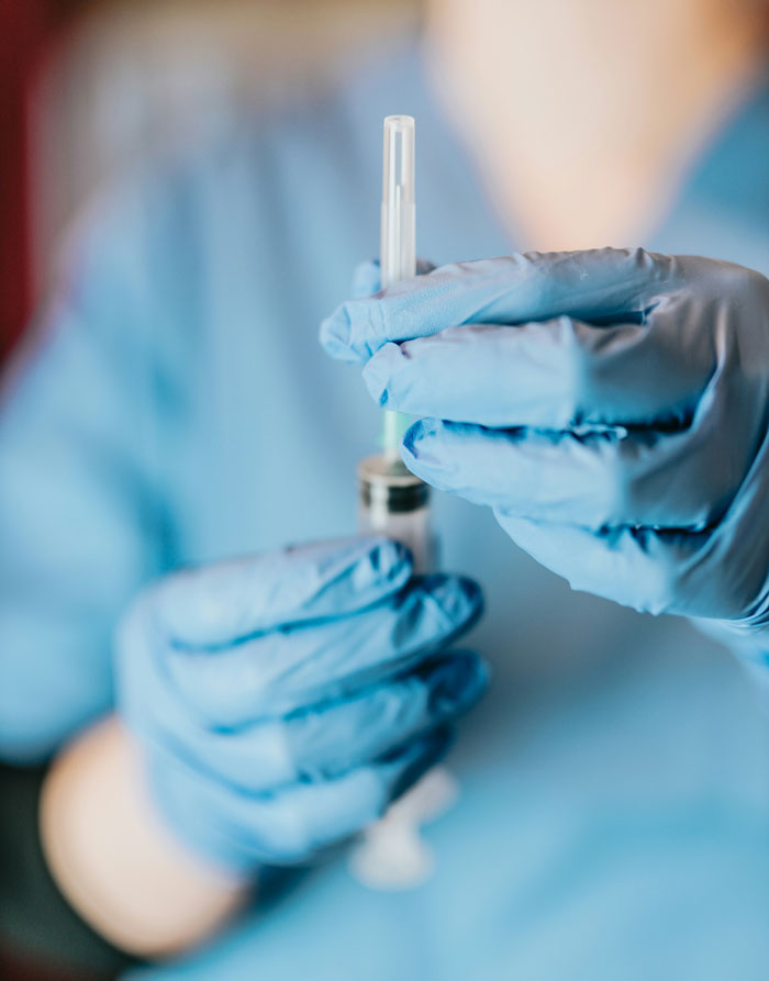 Healthcare worker wearing blue gloves preparing a syringe, highlighting common terrifying and horrible mistakes made in hospitals.