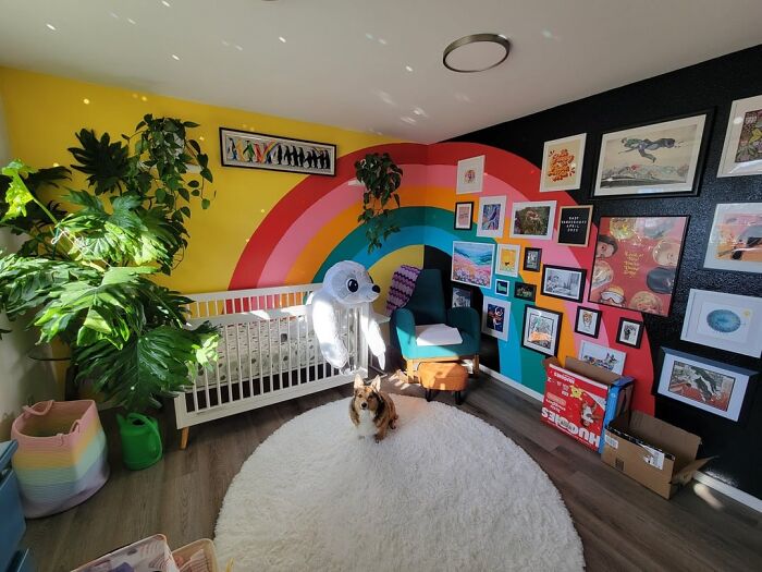 Colorful living space revamp with rainbow wall art, plants, cozy seating, and a small dog on a round rug in a bright room.