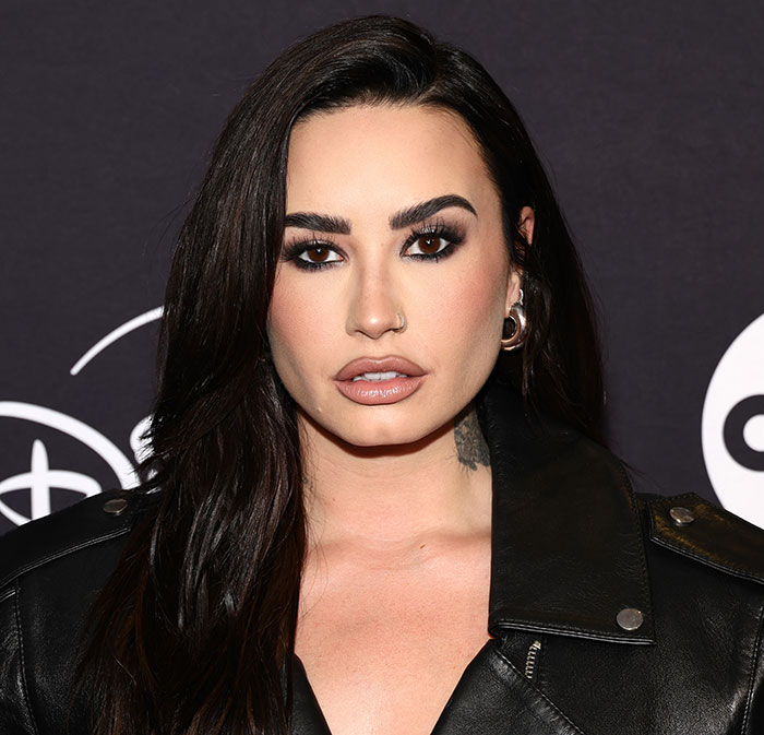 Demi Lovato at an event, wearing a black leather jacket, with dark hair and bold makeup, shocking fans online. Demi Lovato at an event, wearing a black leather jacket, with dark hair and bold makeup, shocking fans online.
