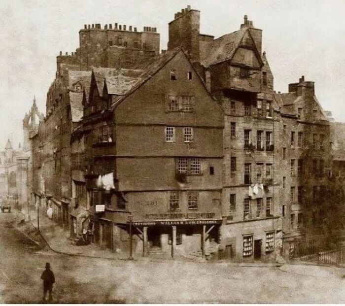 Old architecture of historic multi-story buildings with timber framing and narrow streets in a vintage sepia tone.