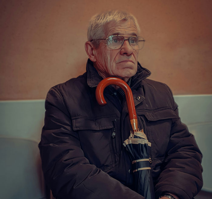 Elderly man holding umbrella, deep in thought, illustrating themes of therapists sharing differences between men and women. - 5