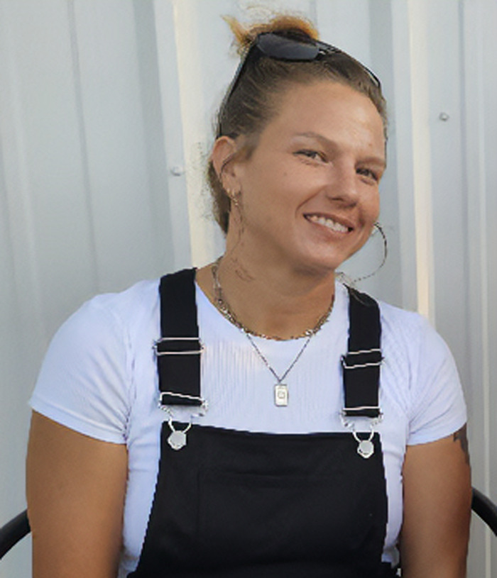 Smiling woman wearing black overalls and white shirt, representing woman who mysteriously vanished in Death Valley. - 1