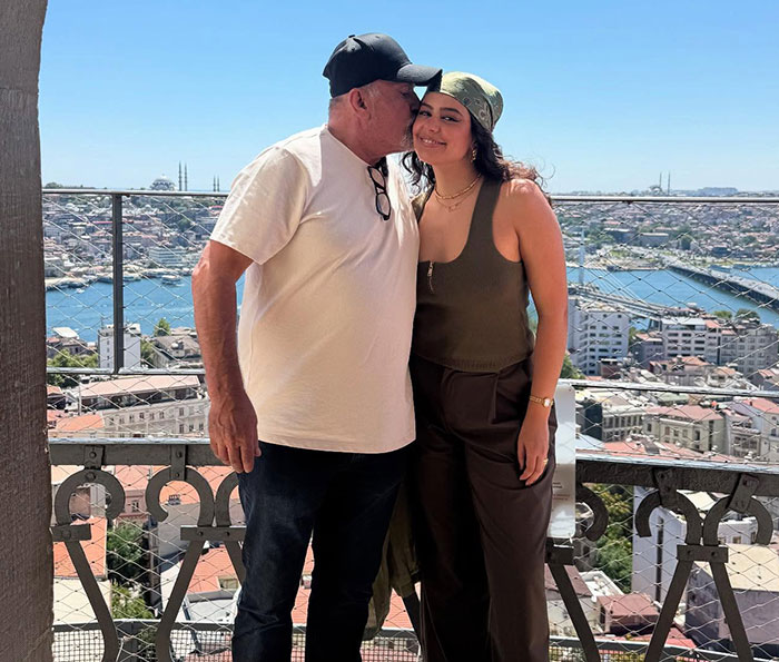 Woman visits family home after 46 years, emotional reunion with dad, scenic city view in background. - 1