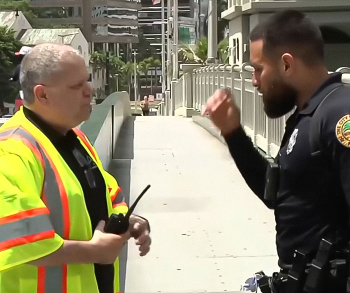 Police officer and safety worker discussing incident near rising drawbridge where woman survived after holding on for dear life. Police officer and safety worker discussing incident near rising drawbridge where woman survived after holding on for dear life.