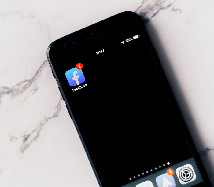 Smartphone screen showing Facebook app with notifications, highlighting women sharing inappropriate comments in public spaces.