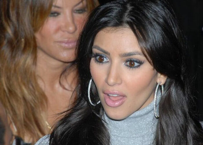 Close-up of a shocked woman with dark hair and hoop earrings, related to the KarJenner clan controversies and actions. - 4