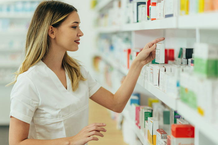 Female medical professional selecting medication from shelf, highlighting concerns about patient privacy in healthcare settings. - 15