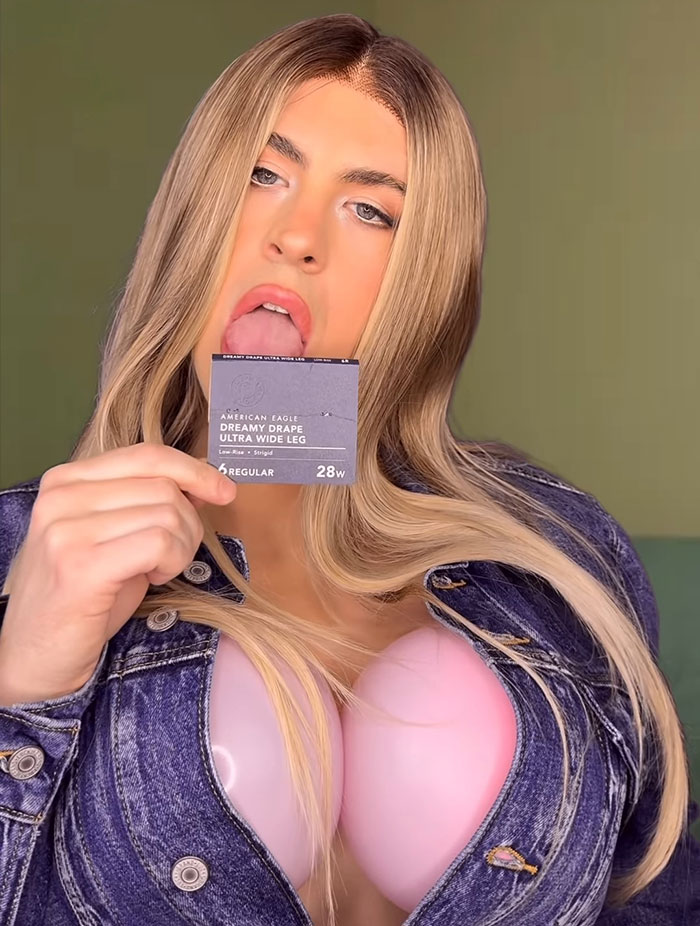 Person with long blonde hair wearing a denim jacket and holding an American Eagle jeans tag near their mouth. - 3