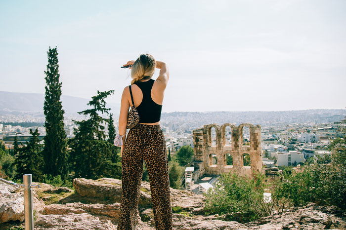 Woman overlooking ancient ruins in a scenic landscape, illustrating bizarre laws including a Norwegian town that banned death. - 1