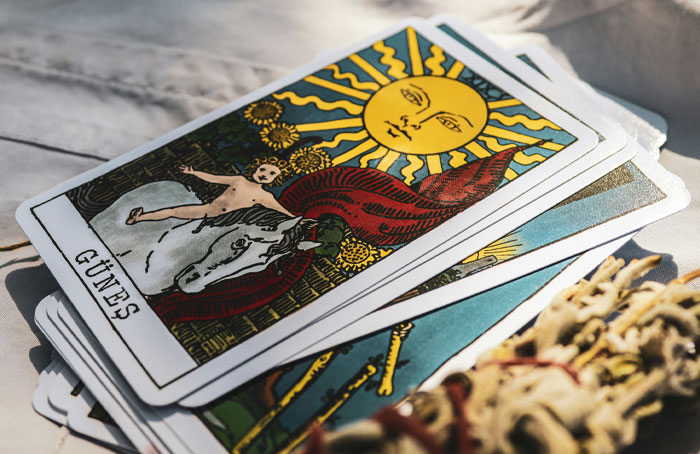 Stack of colorful tarot cards with the sun card on top, illustrating mystical themes in bizarre law stories including a Norwegian town. - 7