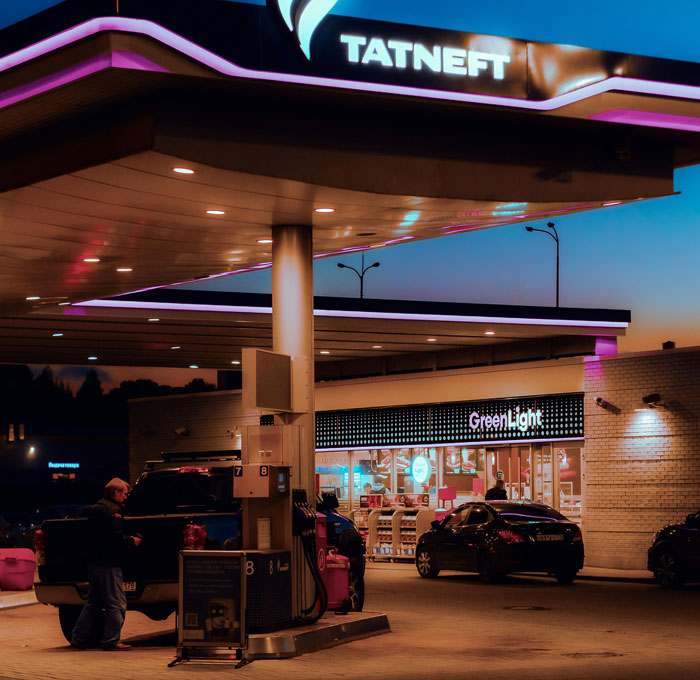 Gas station at dusk with cars and people, illustrating public spaces related to inappropriate comments heard by women.