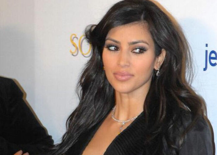 Kim Kardashian posing at an event with long dark hair, wearing a black outfit, related to KarJenner clan controversies. - 20