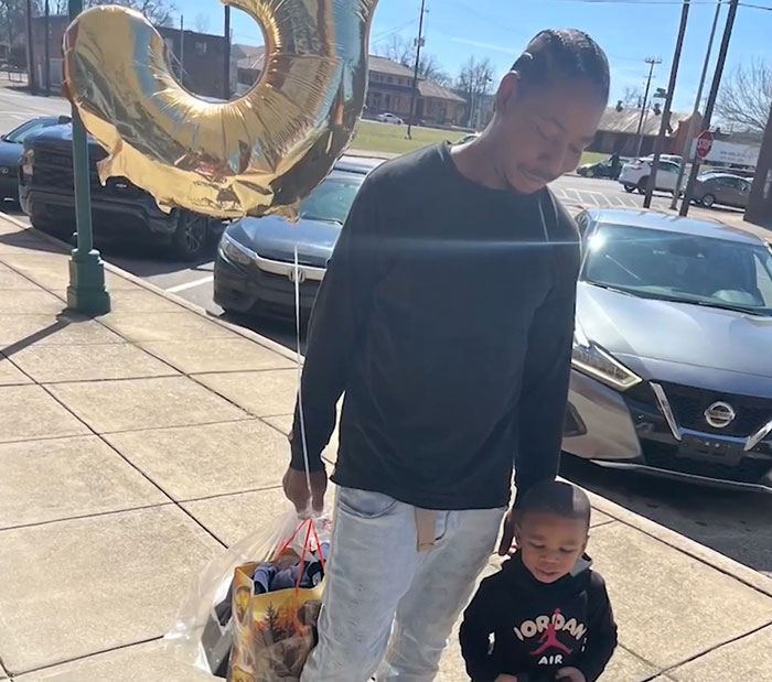 Man holding a gold balloon with a young boy, related to 3-year-old boy in temporary foster care news. - 10