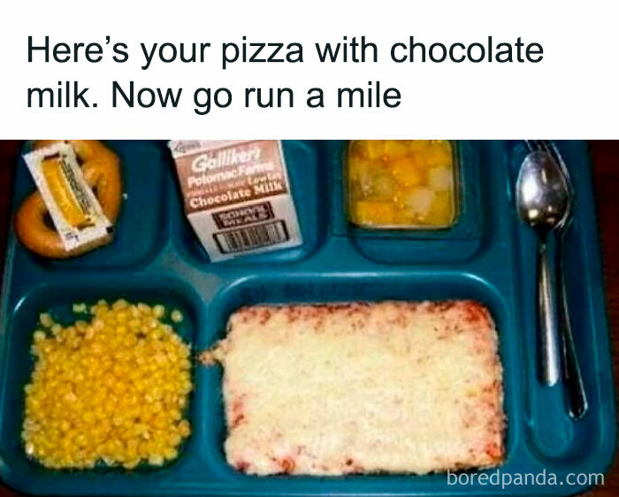 School lunch tray with pizza, chocolate milk, corn, fruit cocktail, and a pretzel, evoking nostalgia for Tamagotchis and VHS tapes.