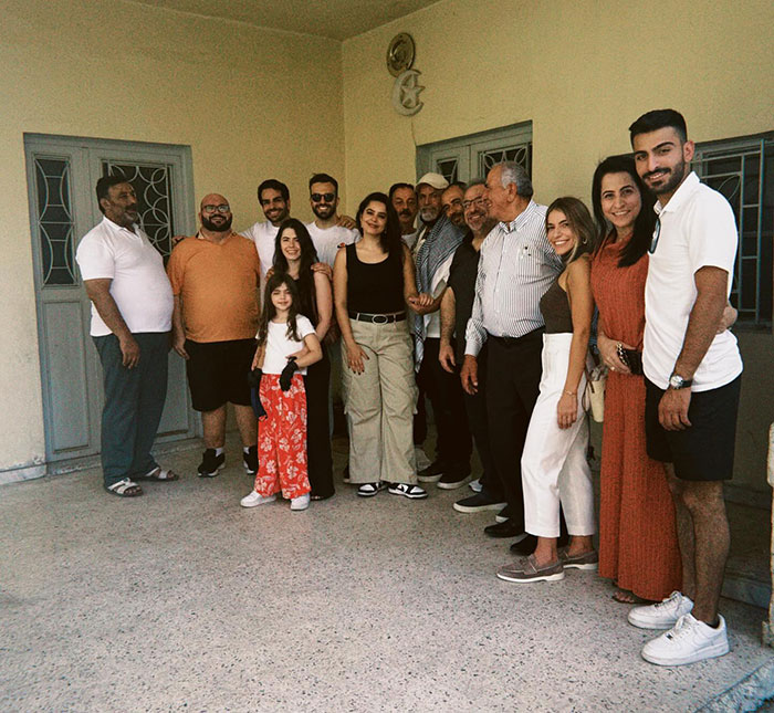 Large family group standing together at a family home during a woman’s visit 46 years after her dad left. - 12