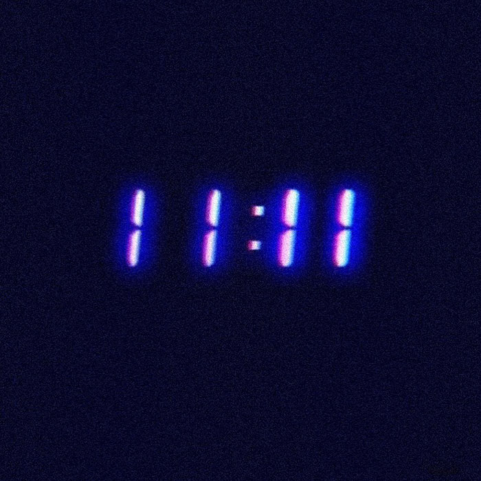 Digital clock displaying 11:11 glowing in blue and purple hues, symbolizing the 111 angel number meaning and spiritual sign.