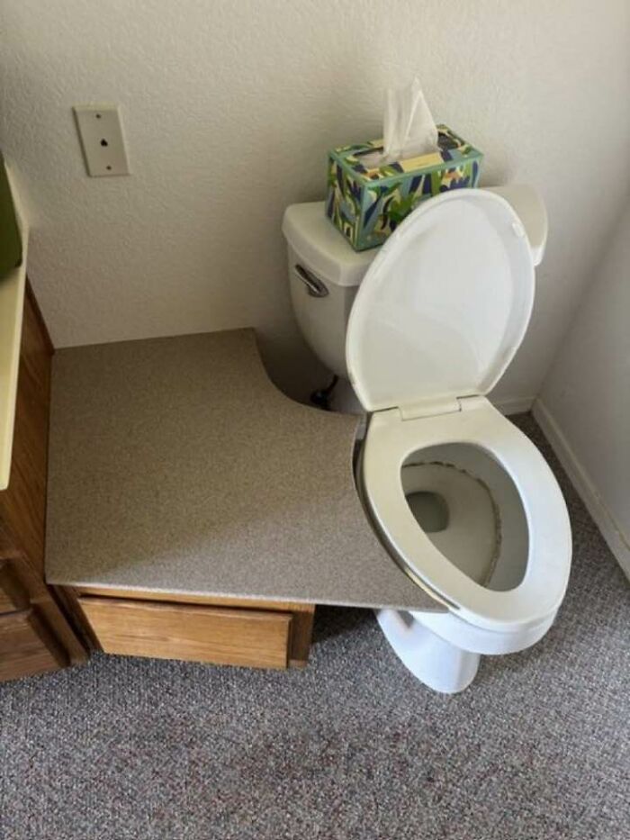 Toilet installed through a kitchen countertop with a tissue box on top, showing a failed home creative idea.