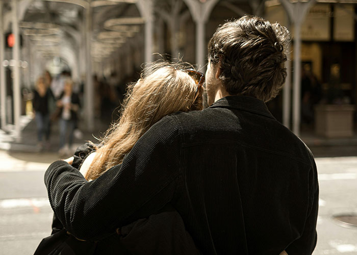 A couple embracing closely on a city street, hinting at themes of relationships and cheating stories.